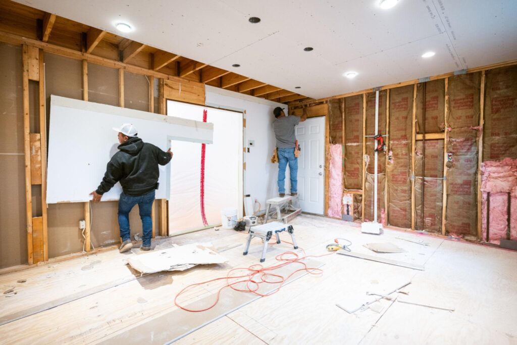 Contractor installing fire-resistant drywall during a residential remodeling project.