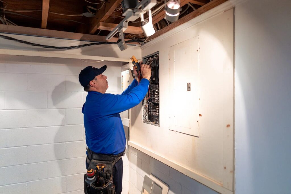 Licensed electrician inspecting a home's electrical system to identify potential fire hazards.