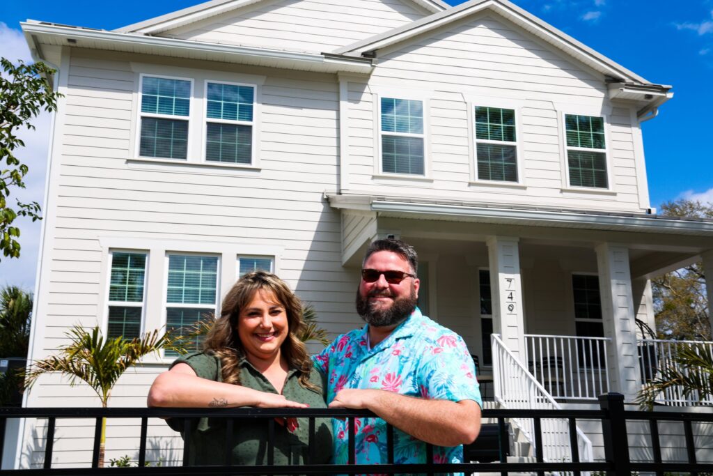 Happy Florida homeowners standing outside their hurricane-ready home after completing professional safety upgrades.