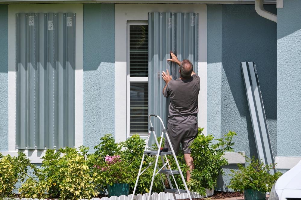 Contractor installing hurricane shutters to protect a Florida home before hurricane season.