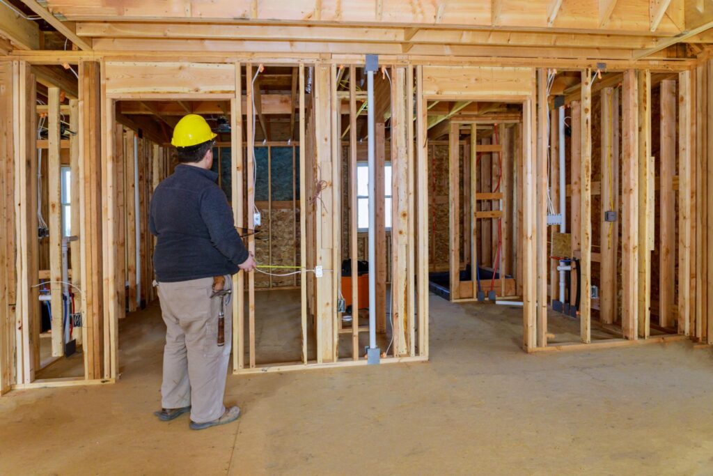 Licensed contractor inspecting a home addition to ensure structural quality and code compliance.