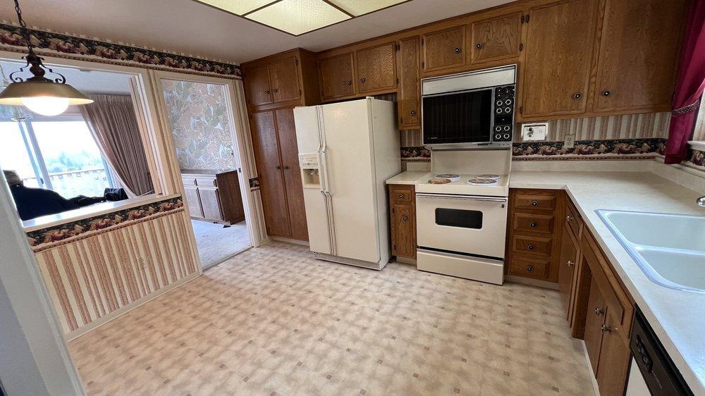 Outdated kitchen with aging white appliances that are no longer energy efficient.