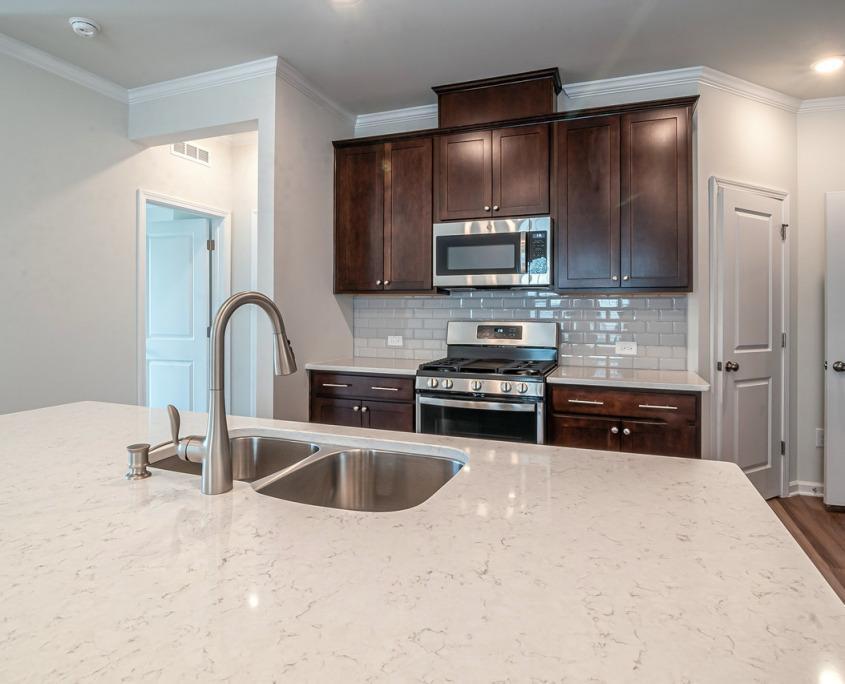 Contemporary kitchen with quartz countertops, subway tile backsplash, and updated lighting.