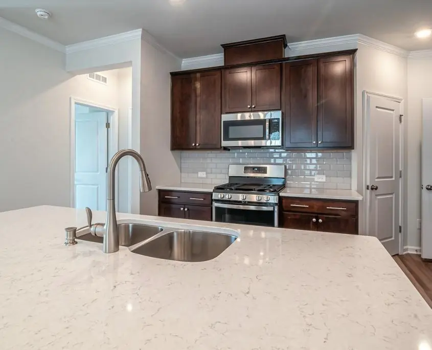 Contemporary kitchen with quartz countertops, subway tile backsplash, and updated lighting.