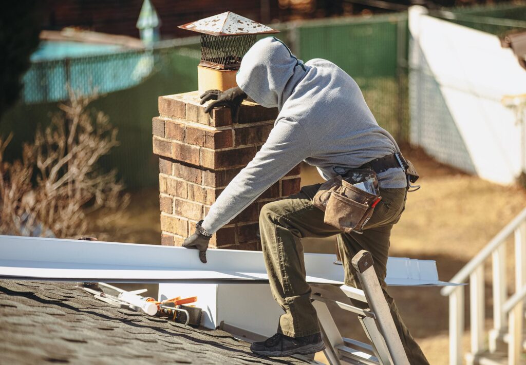 Contractor repairing roof flashing to prevent water intrusion.
