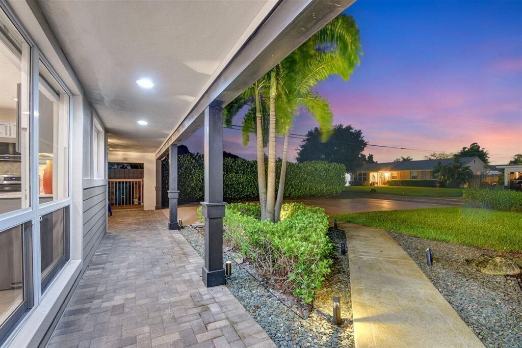 Safe Florida home front entrance with wide steps, handrail, and outdoor lighting
