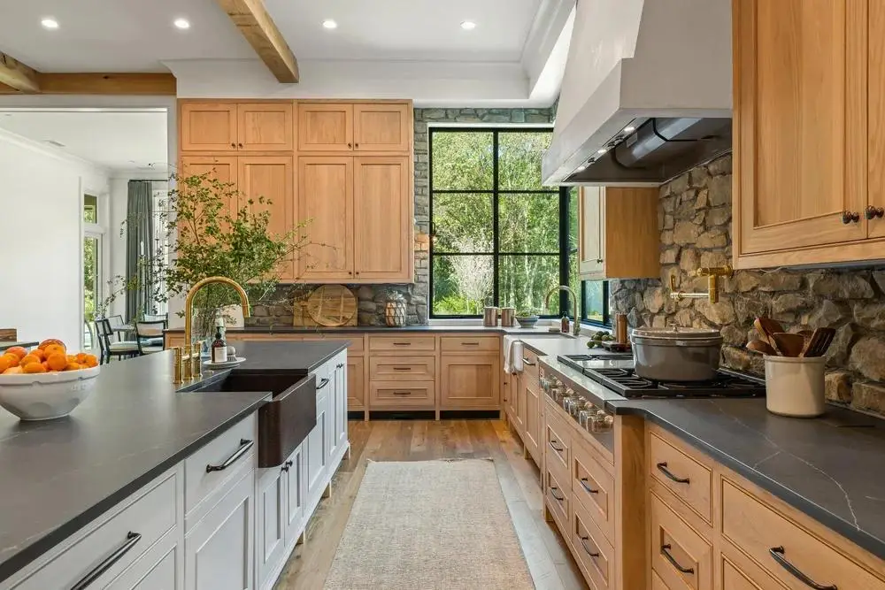 Modern kitchen with white oak cabinets, quartz countertops, and natural stone finishes showcasing warm minimalist design.